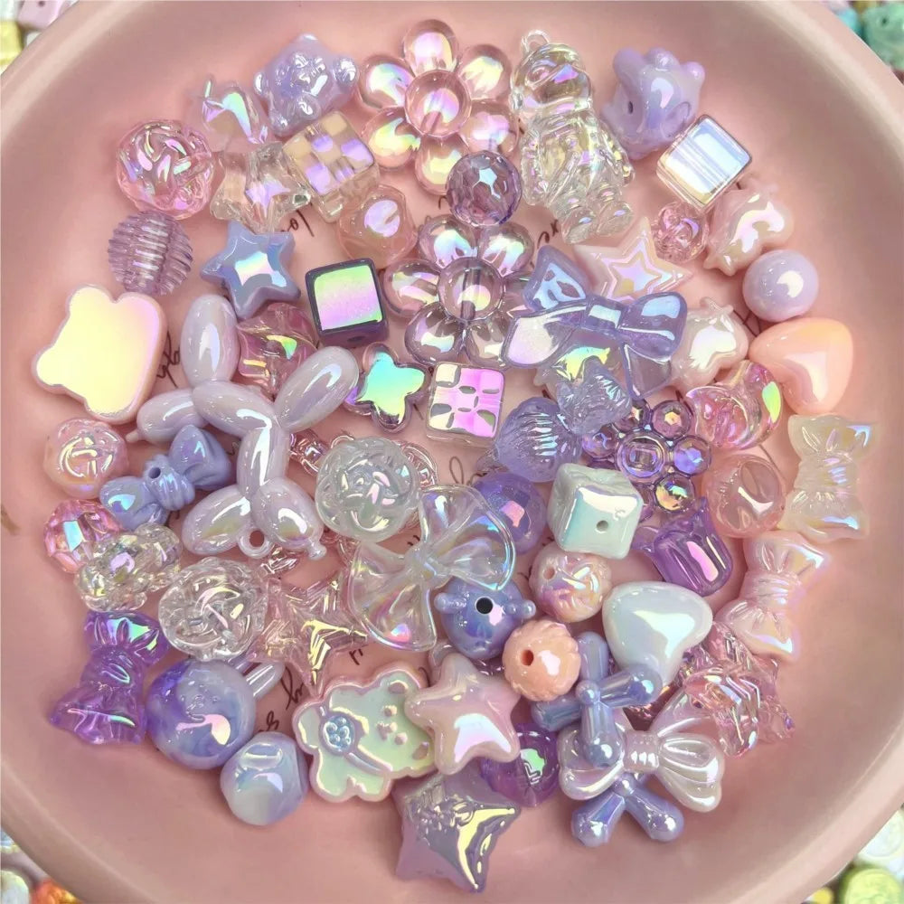 A pink bowl filled with a random mix of purple, pink, and iridescent craft beads including balloon dog, star, and bow shapes.