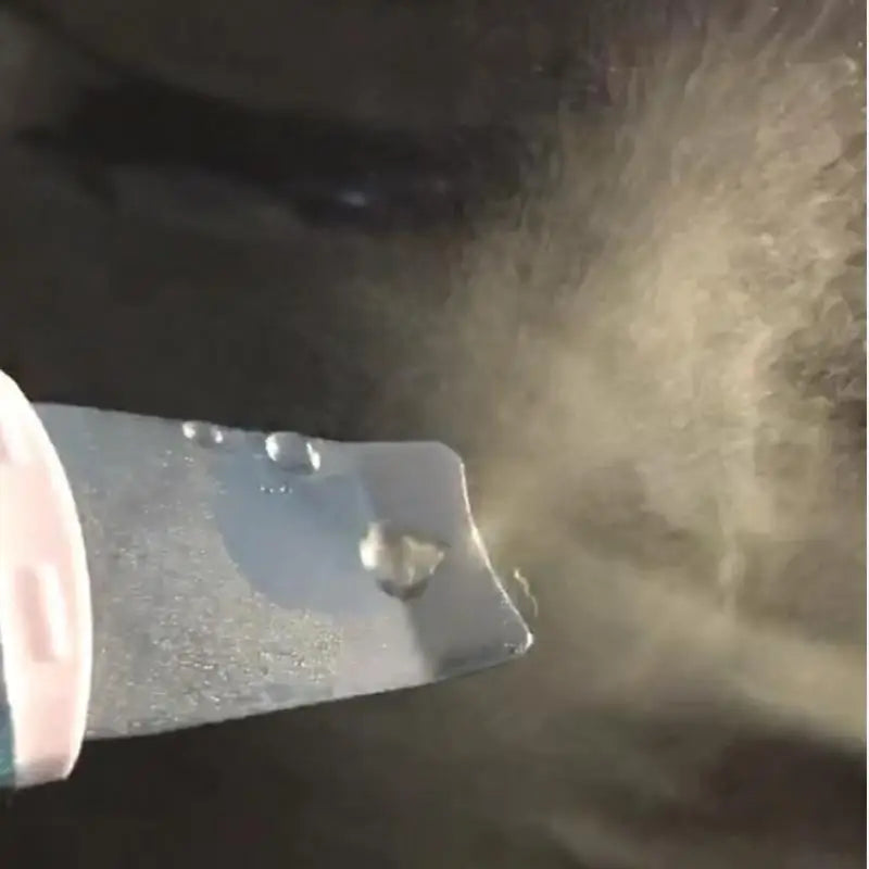 Close-up of metal spatula on facial skin scrubber producing mist