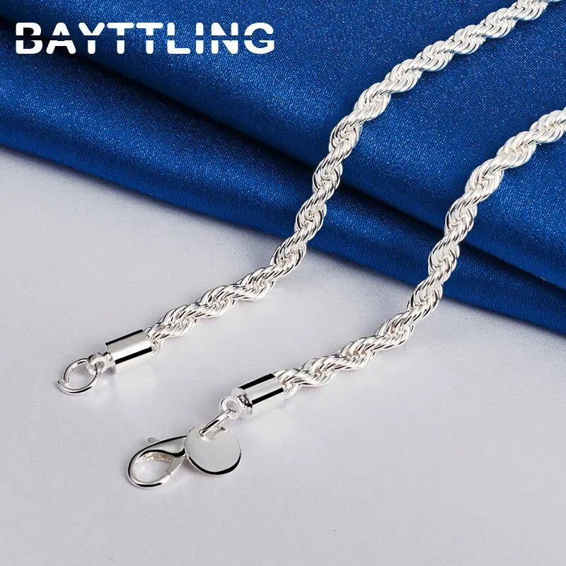 Close-up of silver rope chain necklace clasp on blue fabric