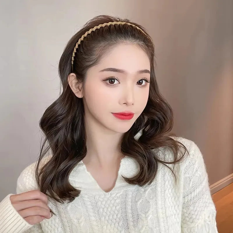 A woman wearing a thin wavy hairband in her hair