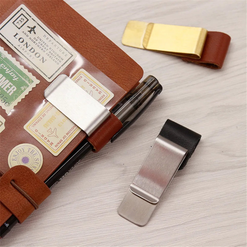 Metal and leather pen holder clips shown with a notebook and pen.