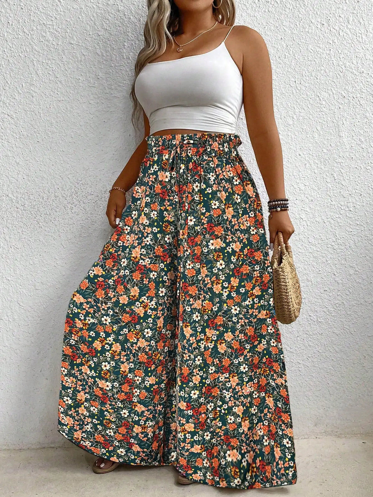 High waisted floral print wide leg pants with an elastic drawstring waist in green, orange, and white.