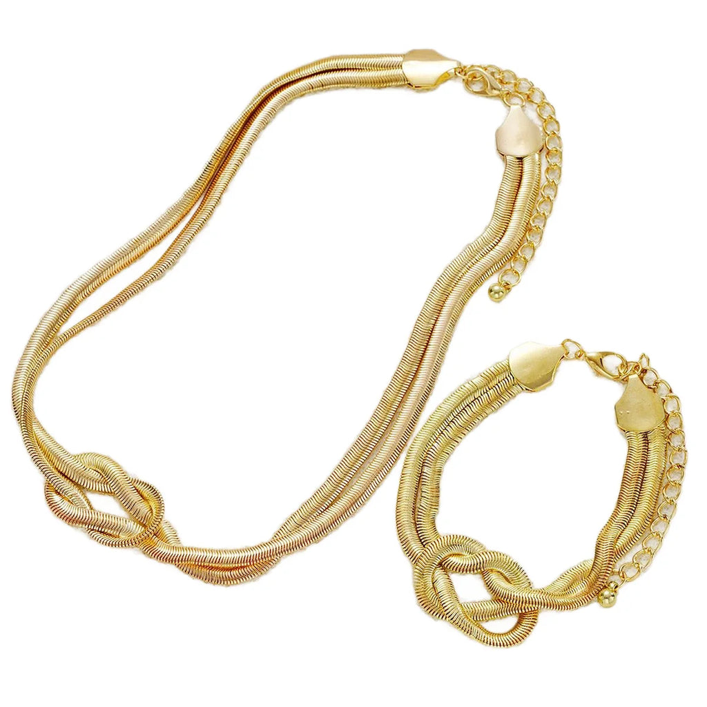 Gold double layer knot necklace and matching bracelet on a white background