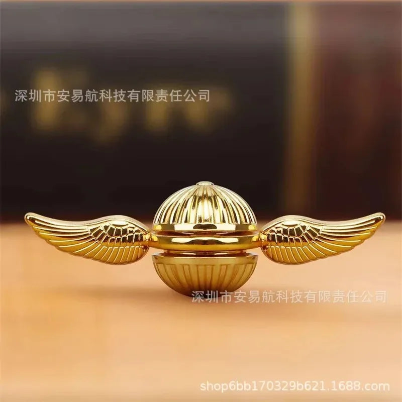 Golden snitch fidget spinner showcased in a studio lighting setup
