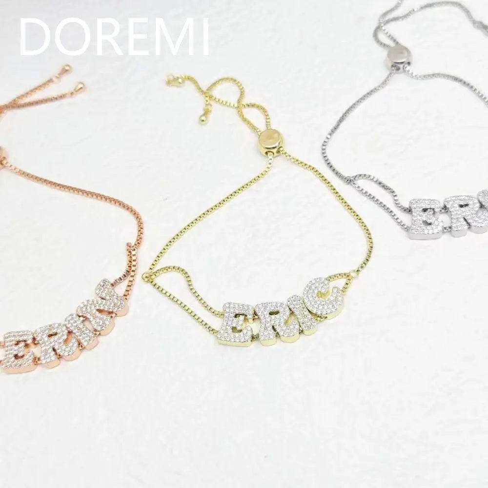 Close-up of three custom alphabet letter slider bracelets in rose gold, gold, and silver tones.