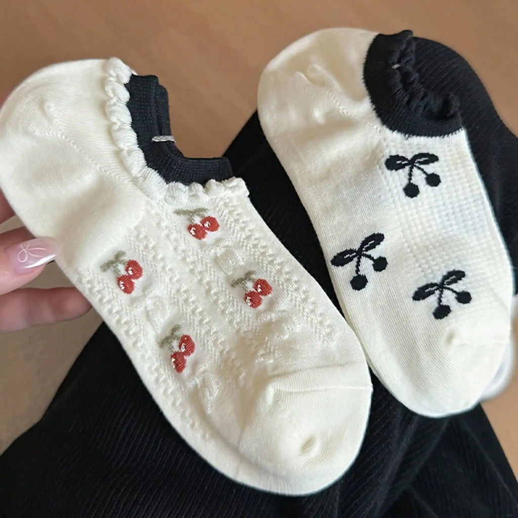Two pairs of white ankle socks with red and black cherry patterns