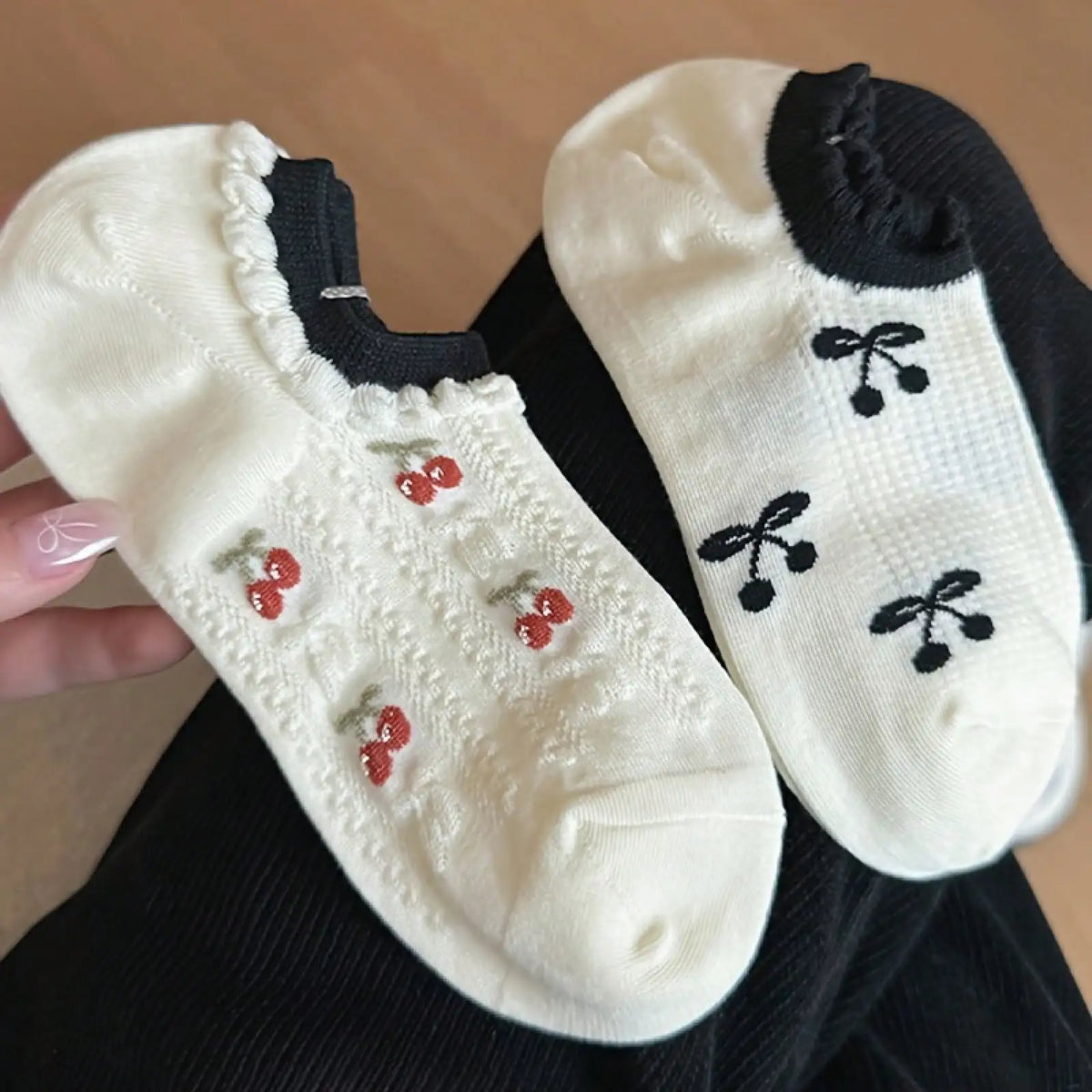 Two pairs of white ankle socks with red and black cherry patterns
