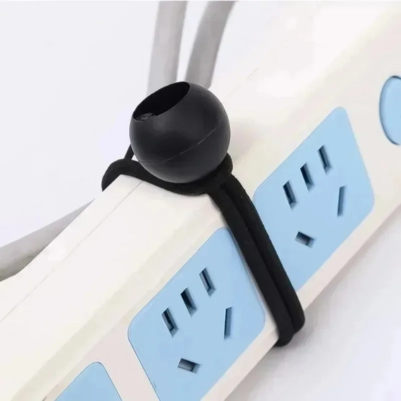 Black elastic bungee cord with a plastic ball used for organizing and securing power cables