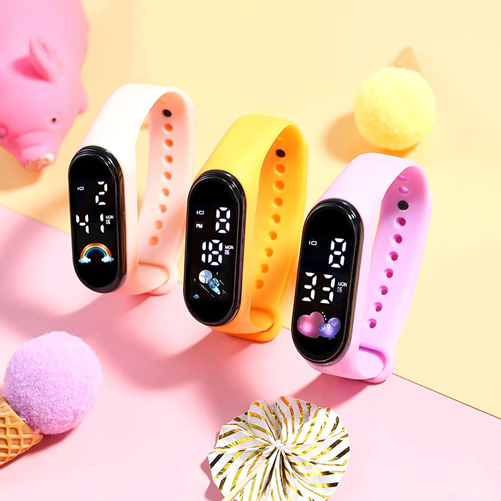 Three colorful digital sports watches for kids placed on a surface with toy decorations.