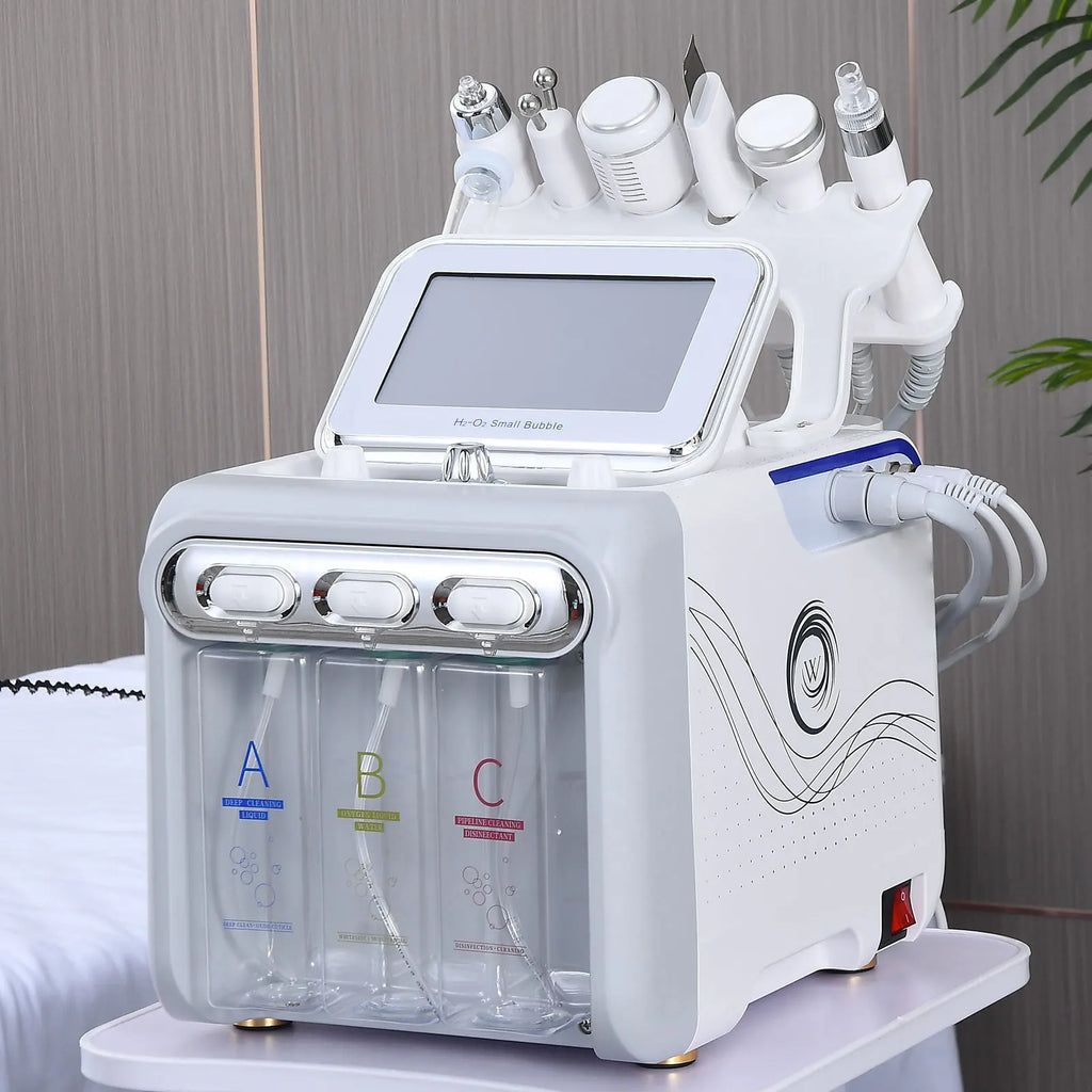 White 6-in-1 facial skincare machine with multiple treatment wands and solution bottles, displayed on a salon table