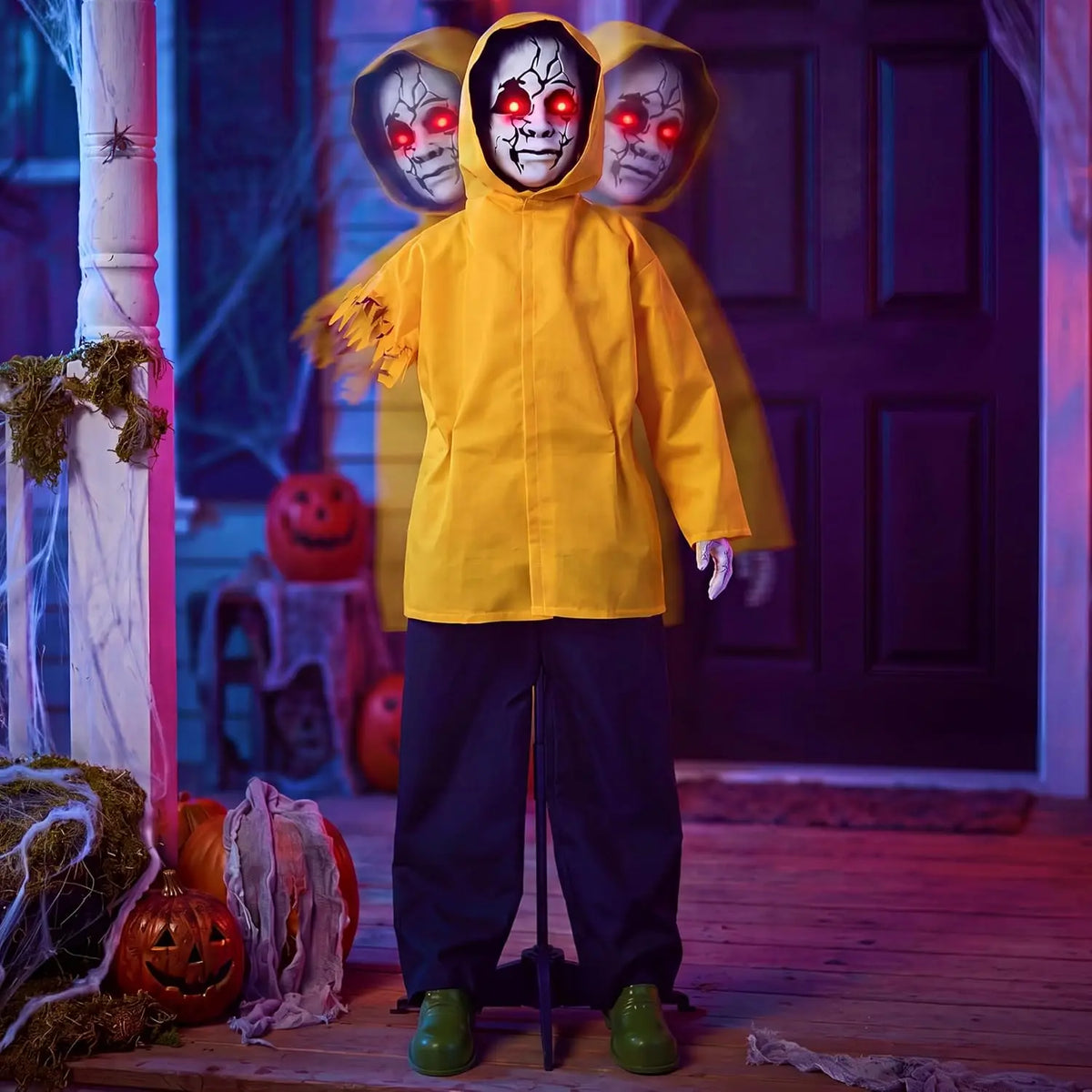 Life-sized Halloween ghost animatronic in a yellow raincoat with red glowing eyes in a yard