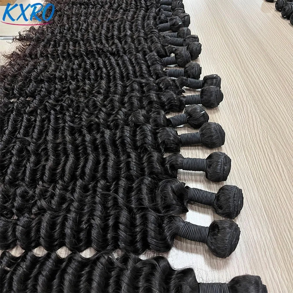 Multiple bundles of long black deep wave hair laid out on a wooden surface.