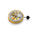 A gold-colored automatic mechanical watch movement with a date wheel on a plain white background