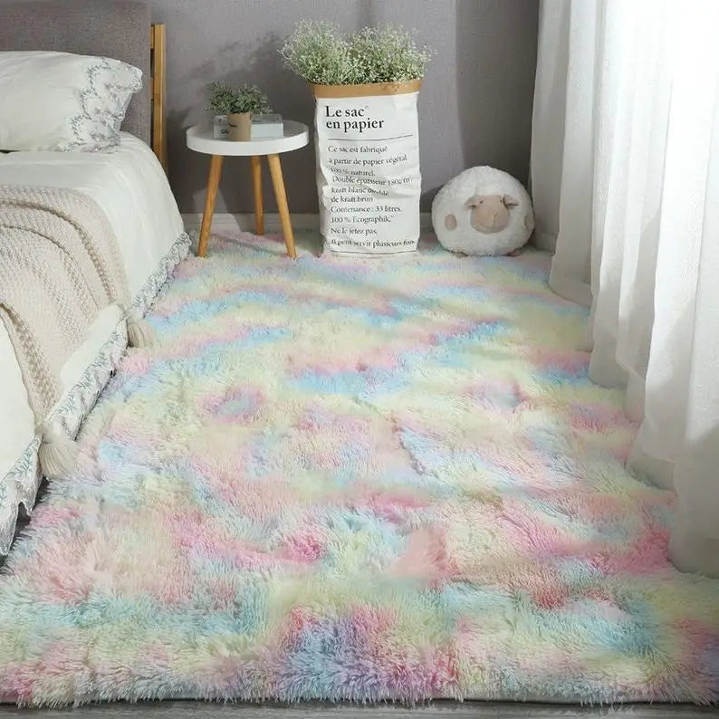 Multicolor pastel rainbow tie-dye style plush area rug in a bedroom.