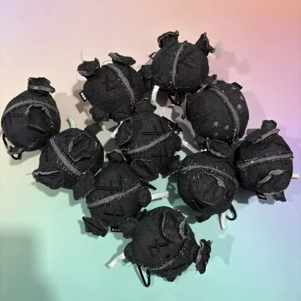 Multiple grey denim plush ball doll pendants with white rope wicks and carabiner clips
