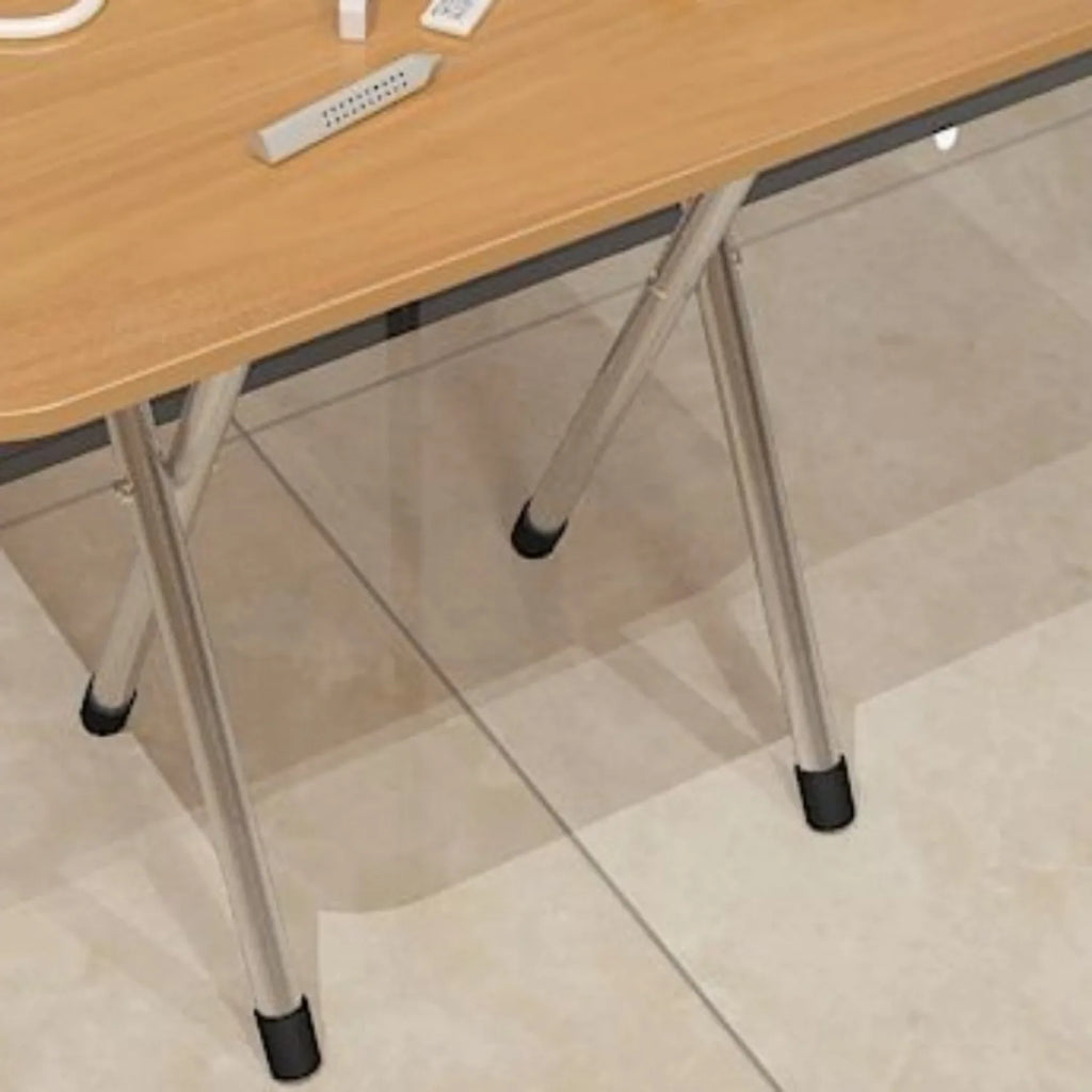 A close-up view of the metal legs and feet of a light wood folding table.