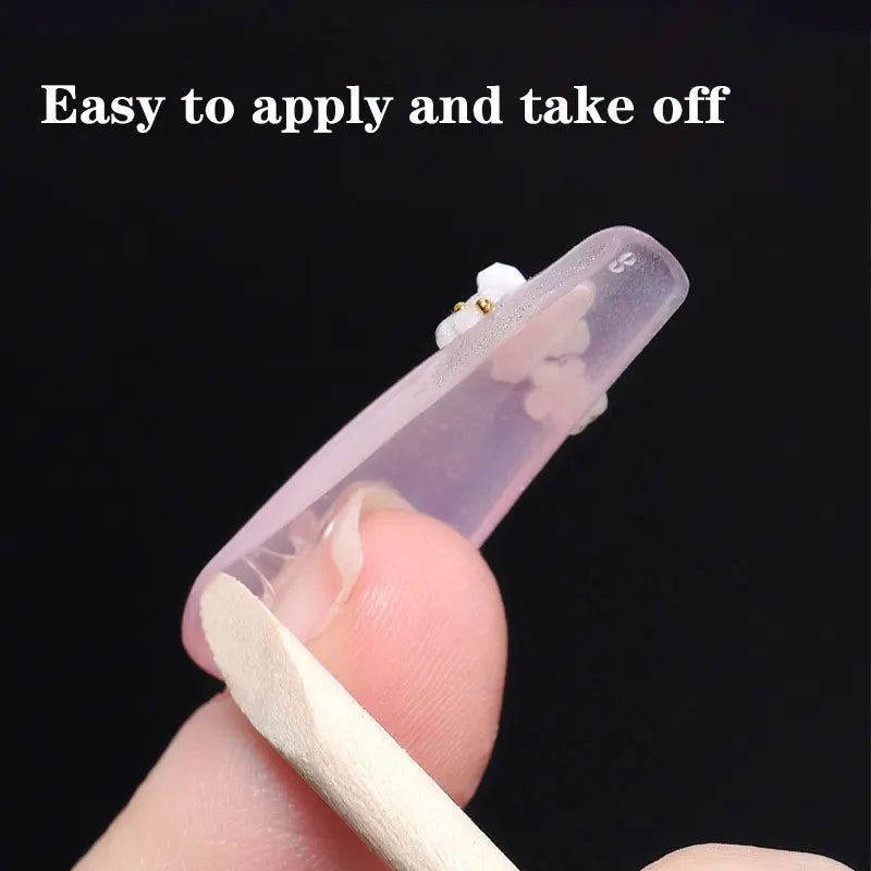 Applying a press-on nail using an adhesive jelly tab and wooden stick