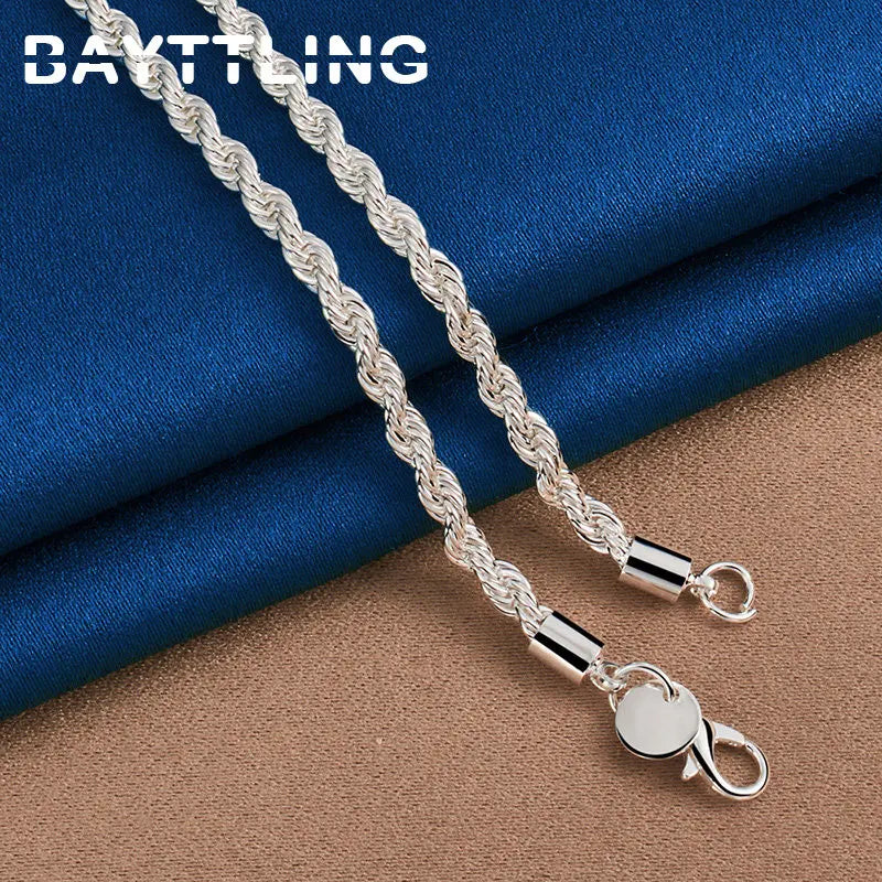 Silver rope chain necklace with lobster clasp on fabric background