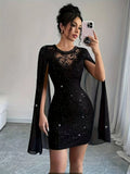 Front view of a woman wearing a black glittery bodycon mini dress with sheer cape sleeves