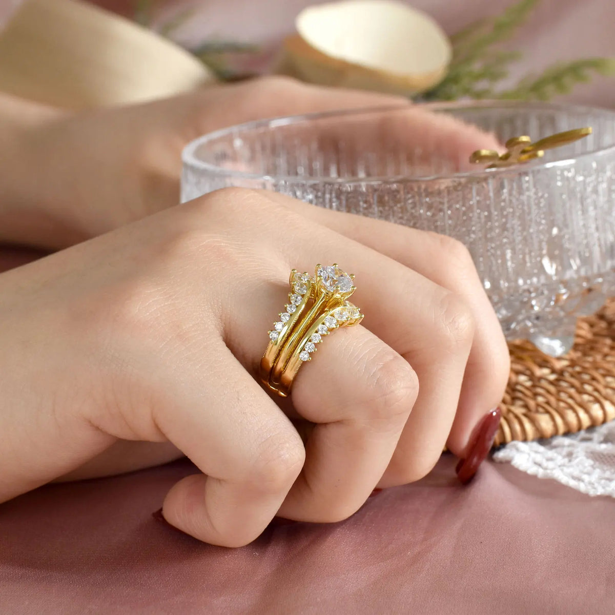 Side view of woman wearing gold plated bridal ring set on her finger