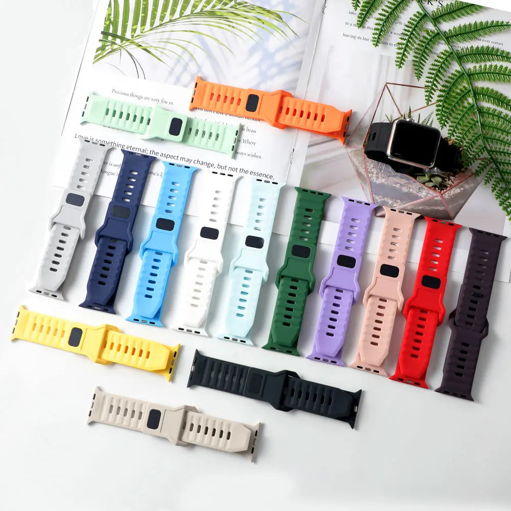 Collection of various colored silicone watch straps laid out with one watch unit.