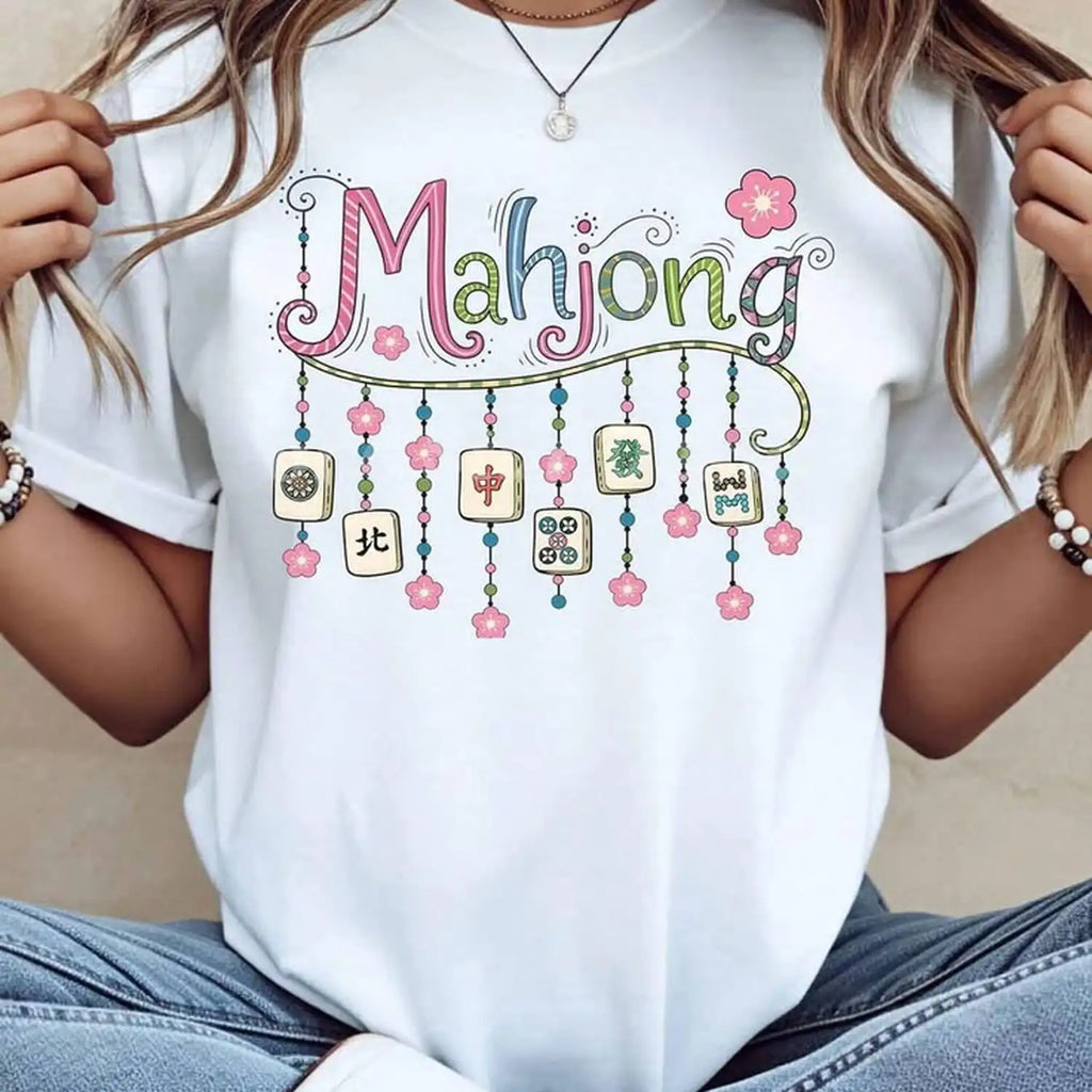 White unisex t-shirt featuring a colorful graphic of Mahjong tiles and floral patterns