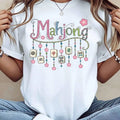 White unisex t-shirt featuring a colorful graphic of Mahjong tiles and floral patterns