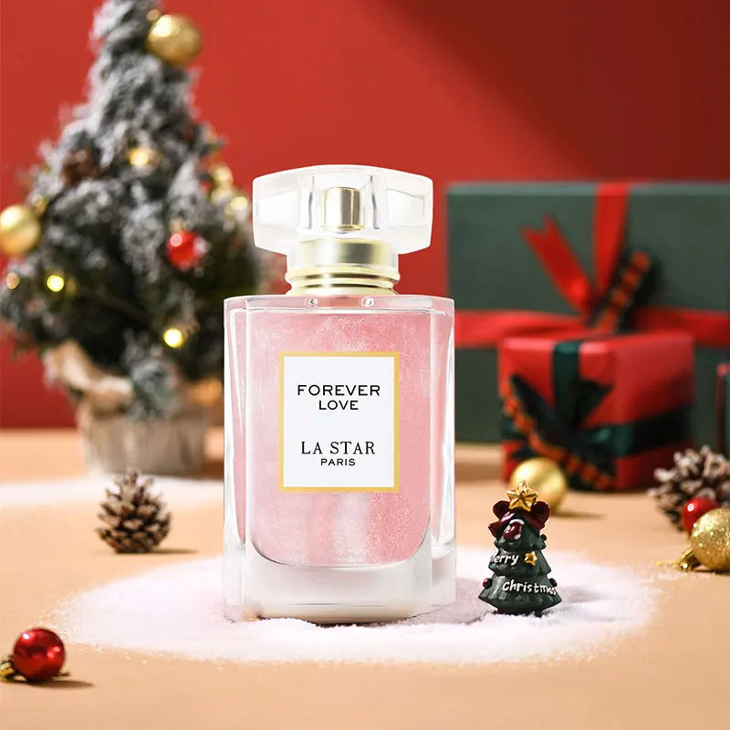 Pink perfume bottle decorated for Christmas with a small festive tree and holiday ornaments