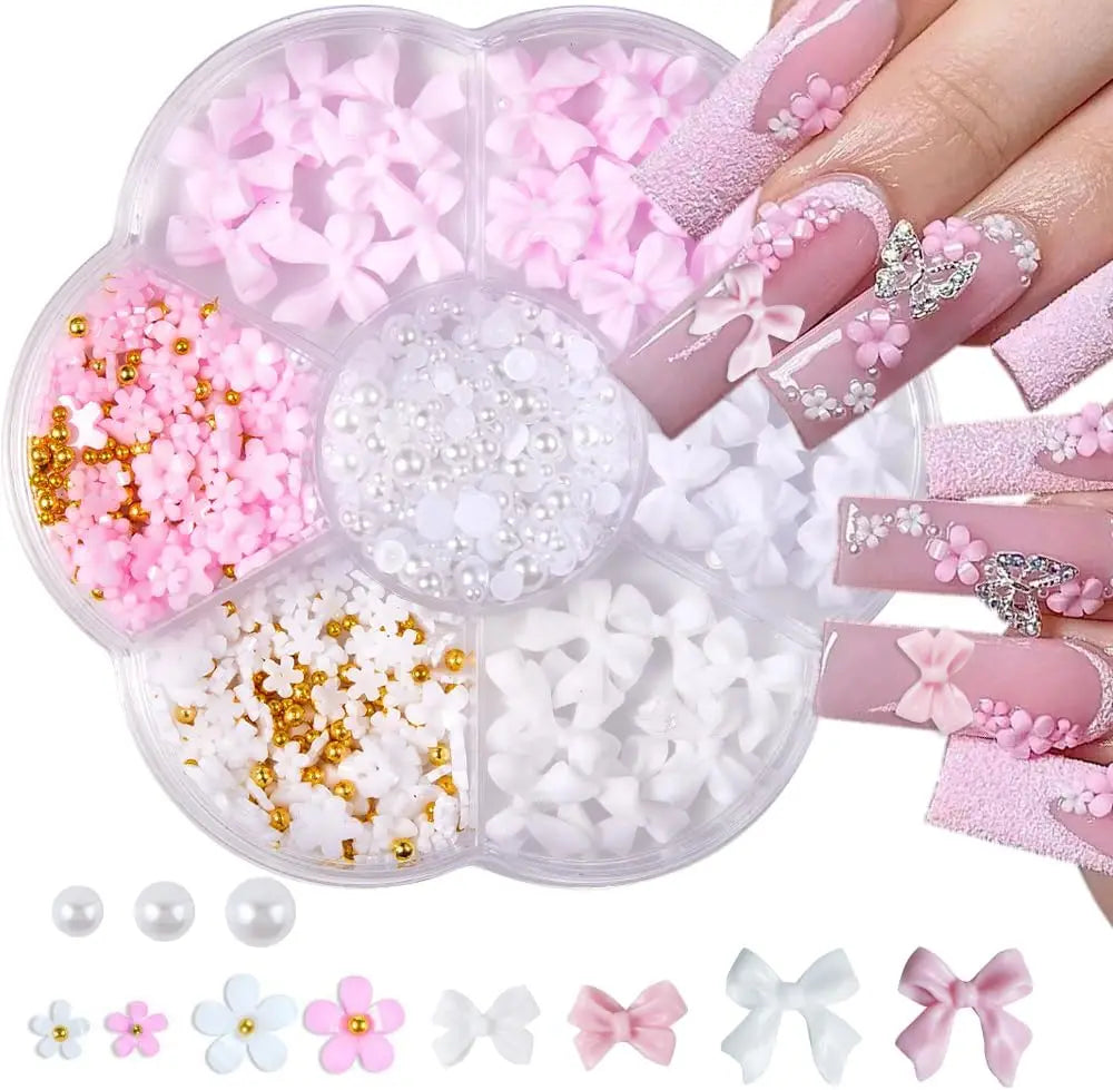 A storage container with various 3D nail art charms like flowers, bows, pearls, and gold beads with manicured nail samples