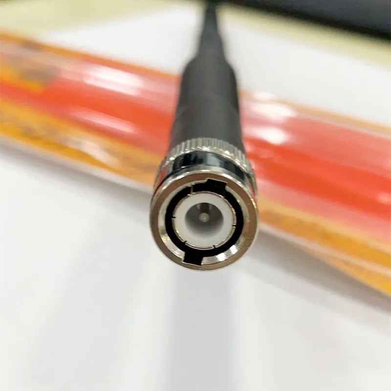 Close-up of a BNC connector on a handheld telescopic radio antenna.