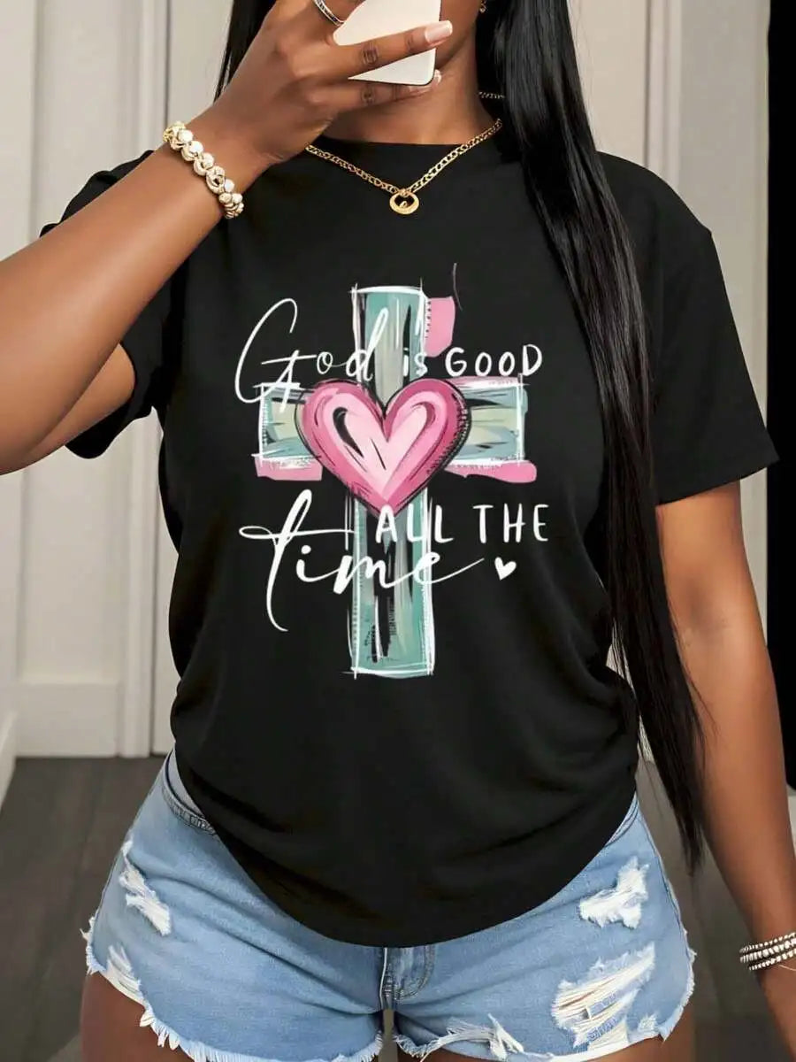 A close-up of a woman wearing a black t-shirt with a religious cross and heart graphic print.