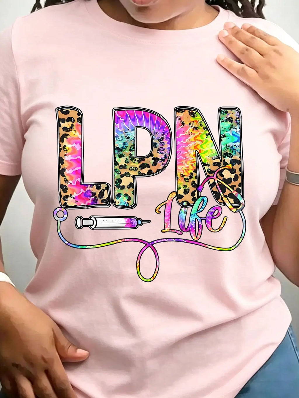 Light pink crew neck t-shirt with leopard and tie-dye graphic text reading LPN Life featuring a syringe and stethoscope