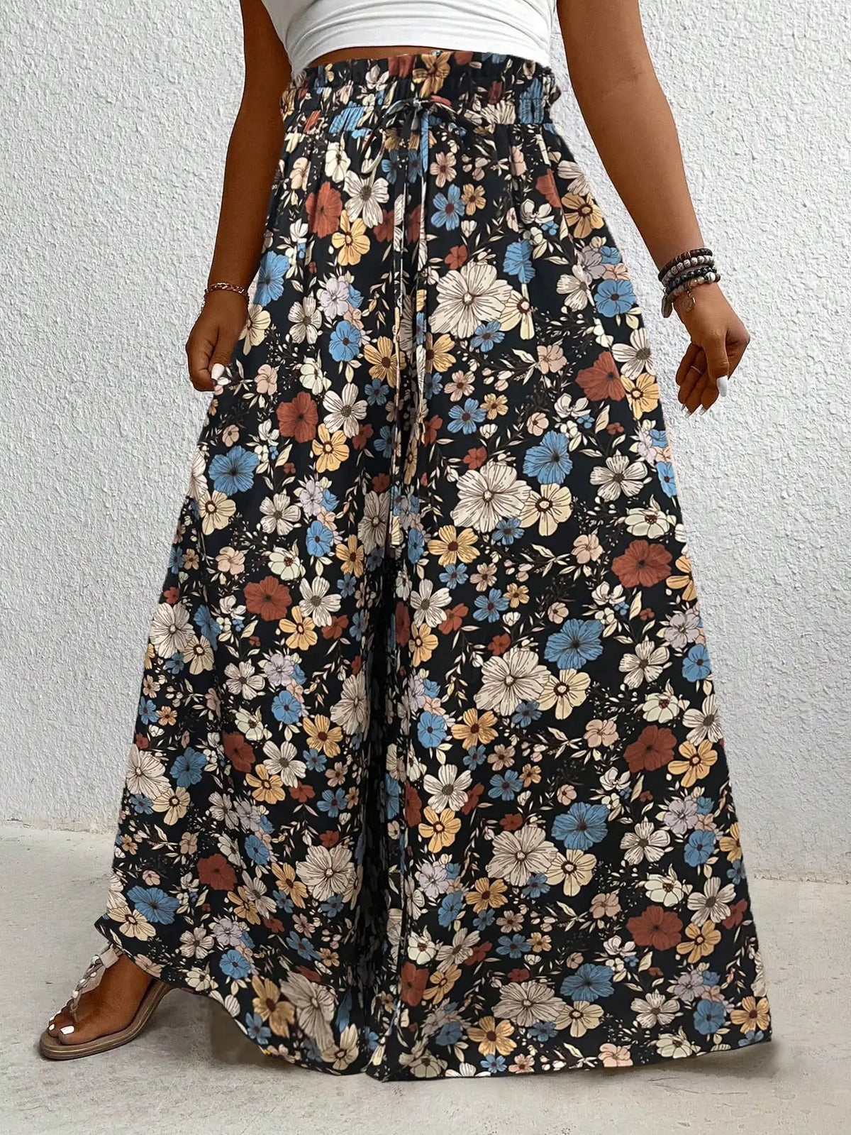 High waisted floral print wide leg pants with an elastic drawstring waist in black, blue, and orange.