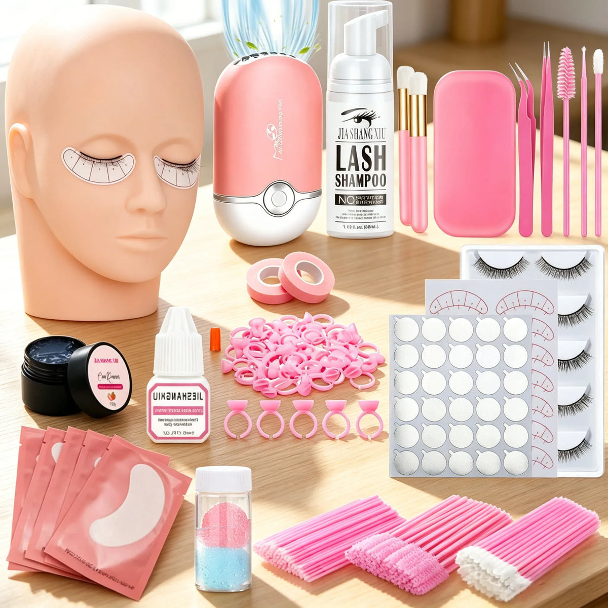 A complete eyelash extension kit featuring a mannequin head, pink portable fan, lash shampoo, tweezers, brushes, and various