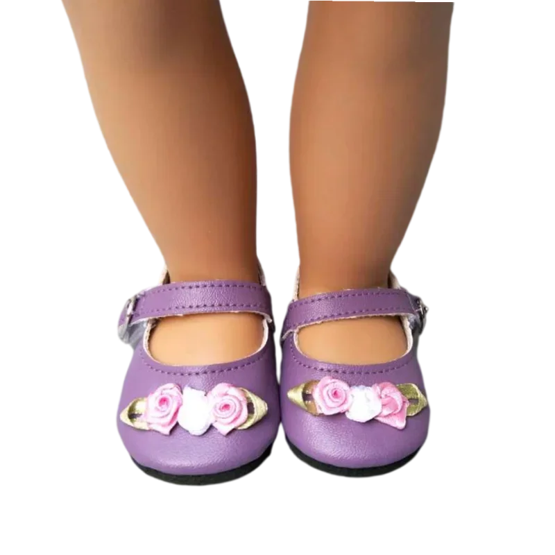 Pair of purple doll Mary Jane shoes with rose details worn on doll legs