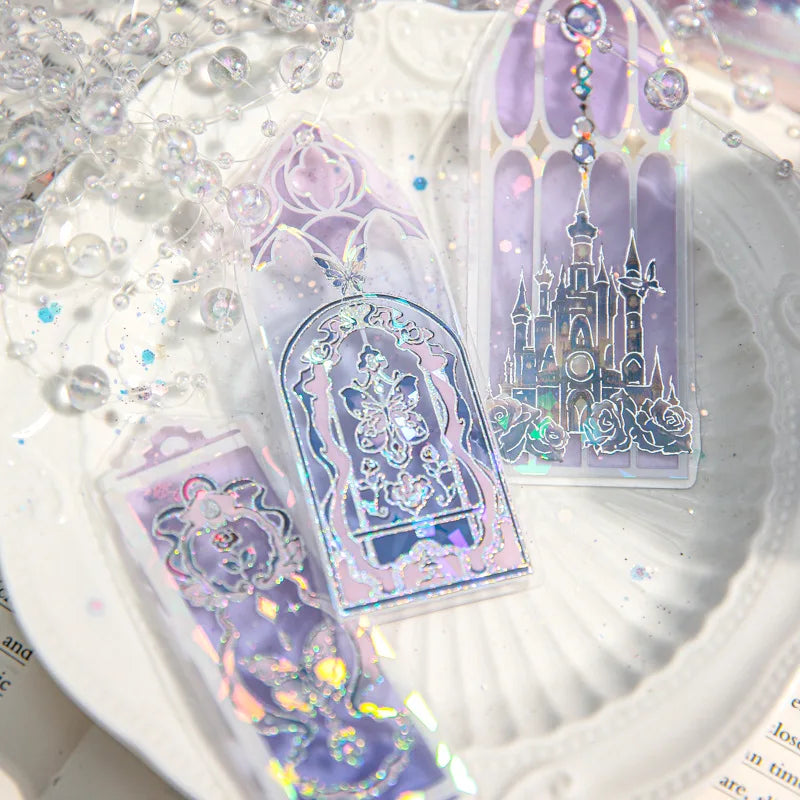 Transparent holographic bookmark set featuring castle and butterfly motifs on a decorative white plate.