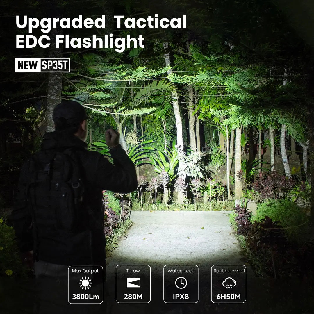 Night time view of person using a powerful tactical LED flashlight in a forest path