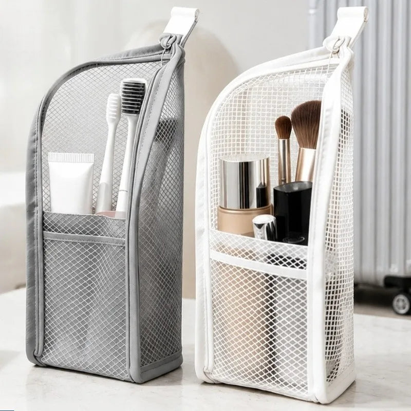 Two portable mesh standing toiletry bags in grey and white containing toiletries and makeup brushes.