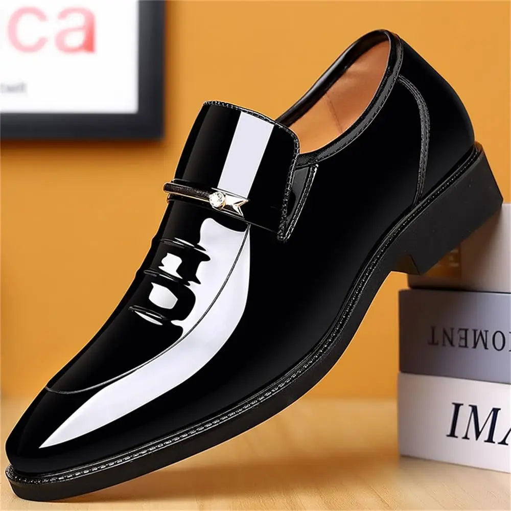 Side profile of a shiny black patent leather slip-on mens loafer with gold hardware.