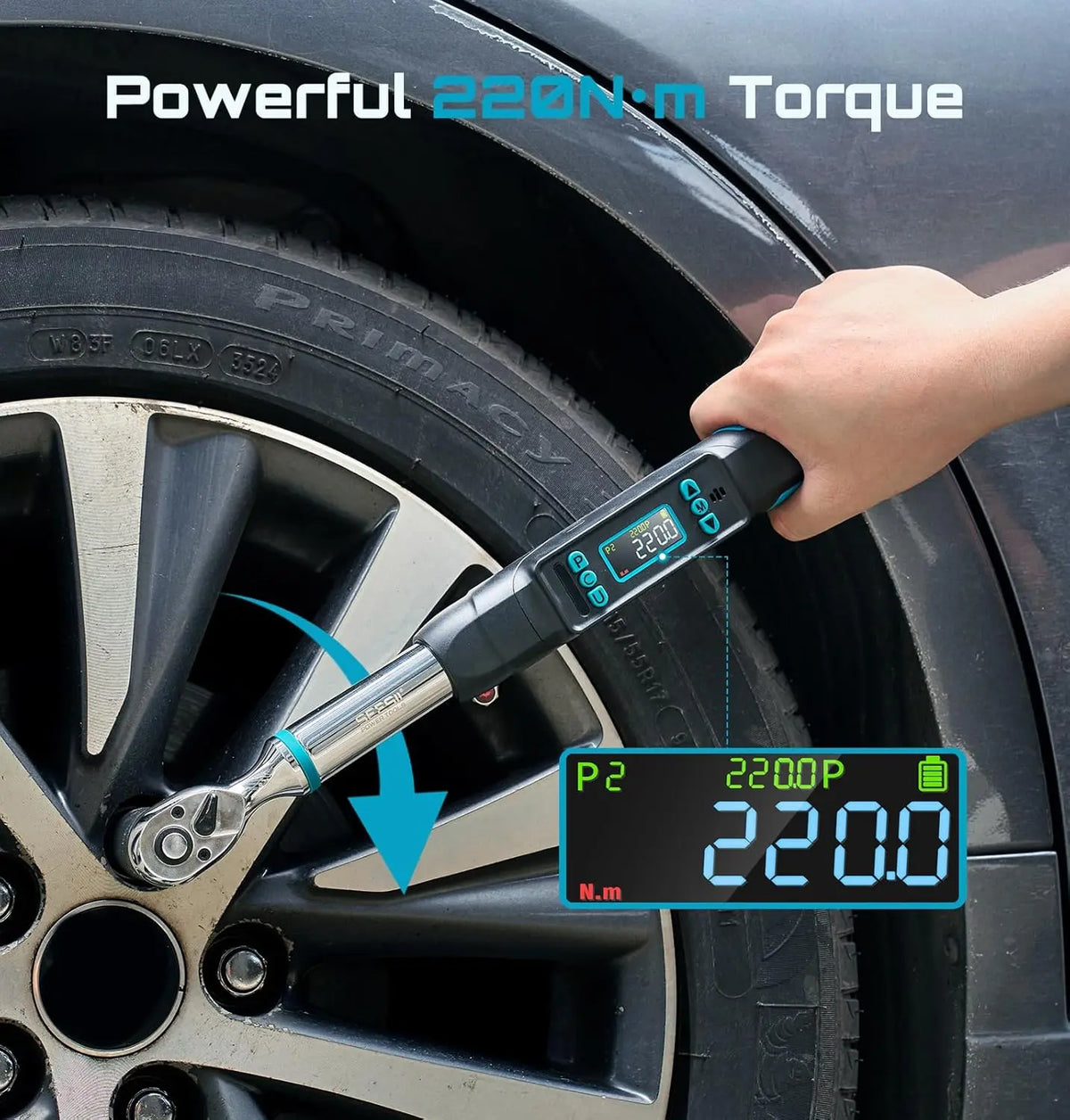 A digital torque wrench used on a car wheel lug nut, displaying a 220Nm torque value on screen.