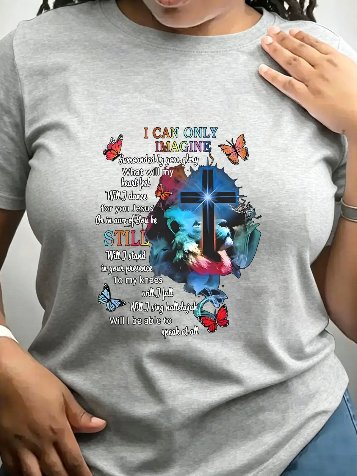 A heather grey short-sleeved crew neck t-shirt with a religious graphic print featuring a cross, lion, butterflies, and