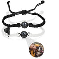 Pair of black and white braided rope bracelets with magnetic heart charms and custom photo projection feature