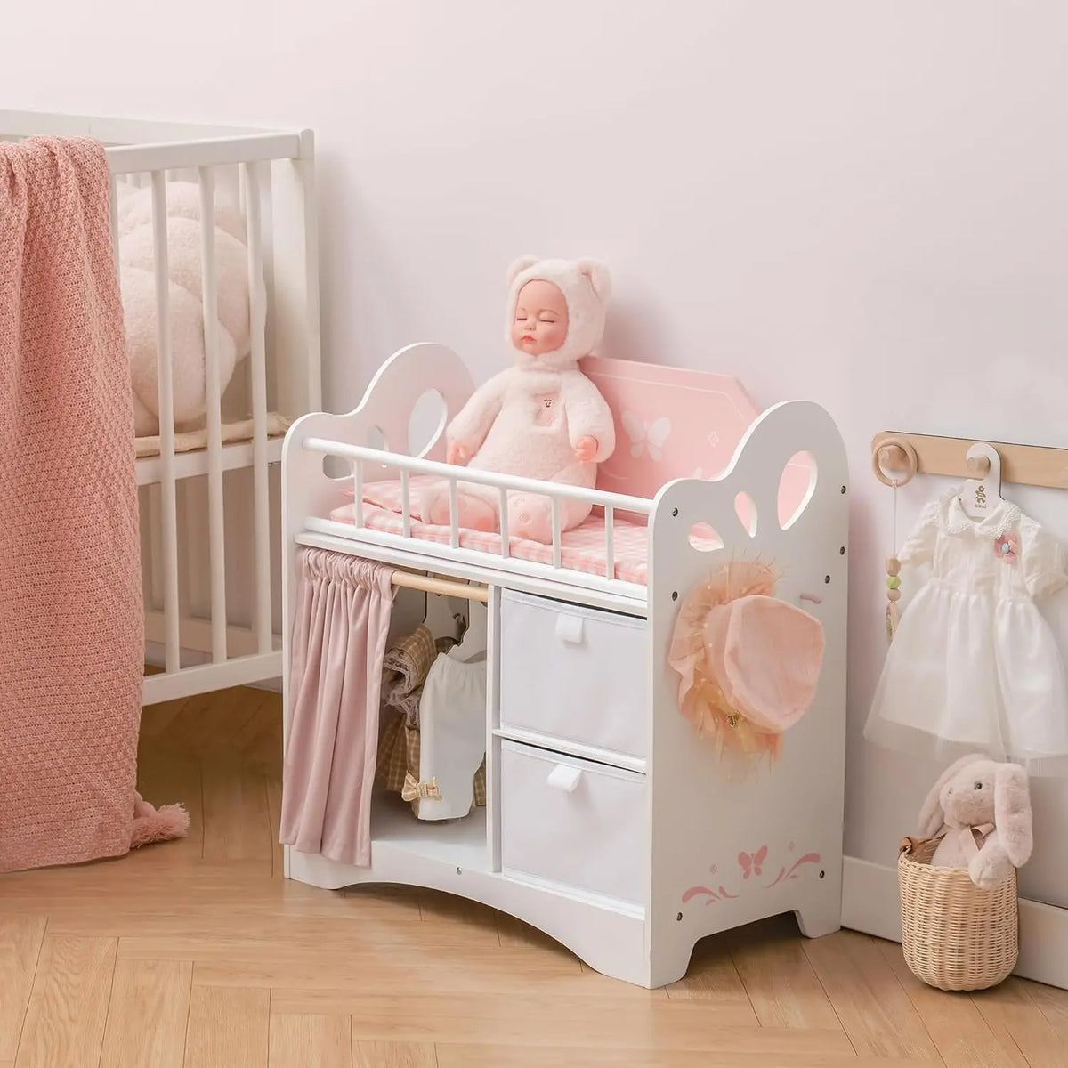 Wooden baby doll crib in a nursery setting with a doll on the bed
