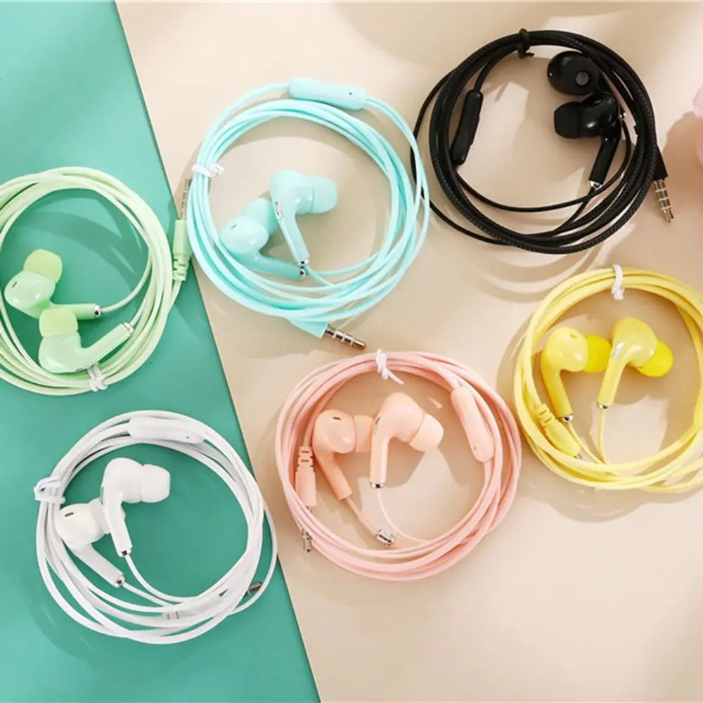 A collection of colorful wired in-ear headphones in black, white, yellow, pink, blue, and light green.