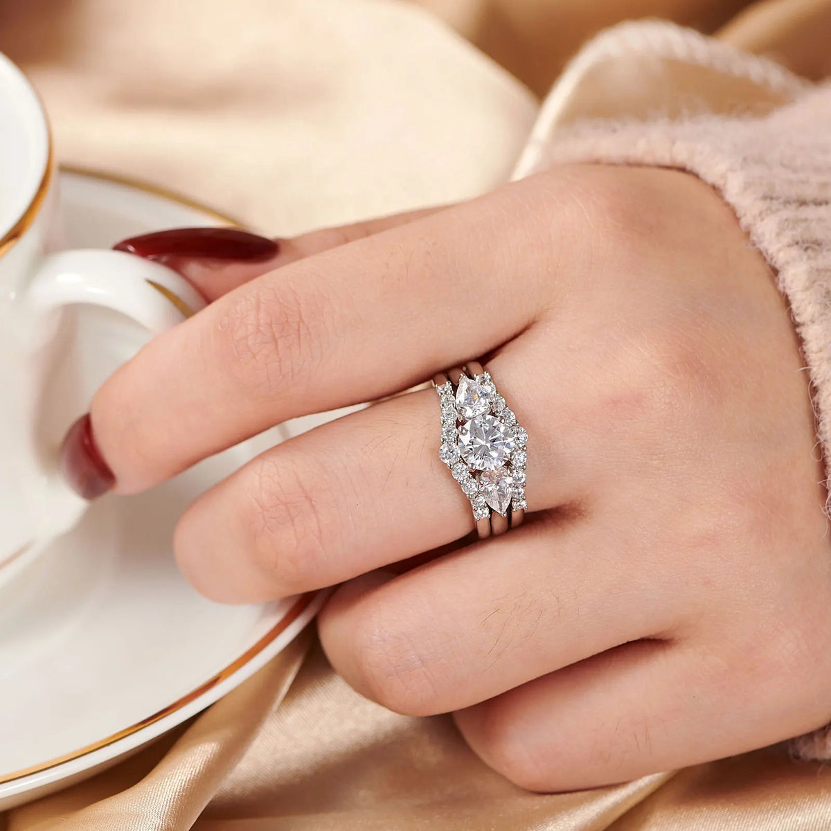 Hand wearing a three-piece sterling silver simulated diamond wedding ring set