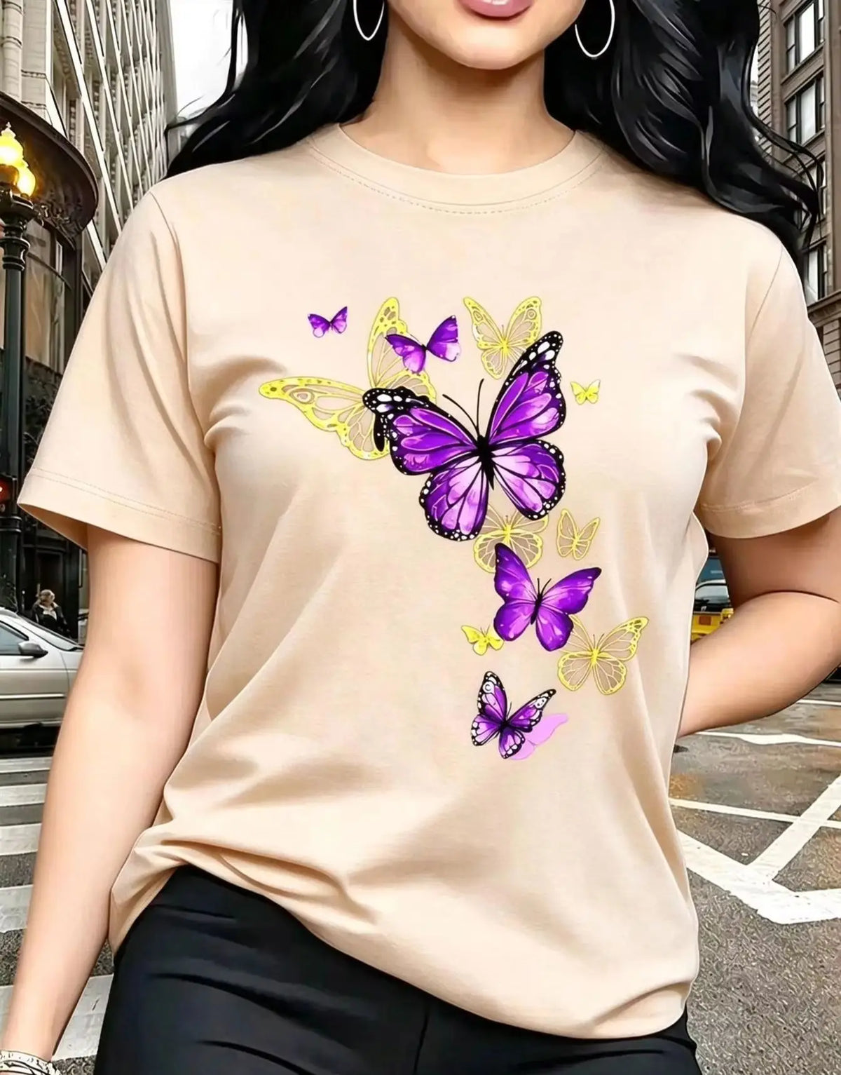 A beige short-sleeved t-shirt with a printed butterfly design, worn by a woman.