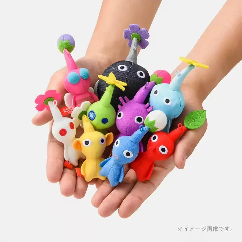A collection of colorful small plant-like creature plush dolls held in hands