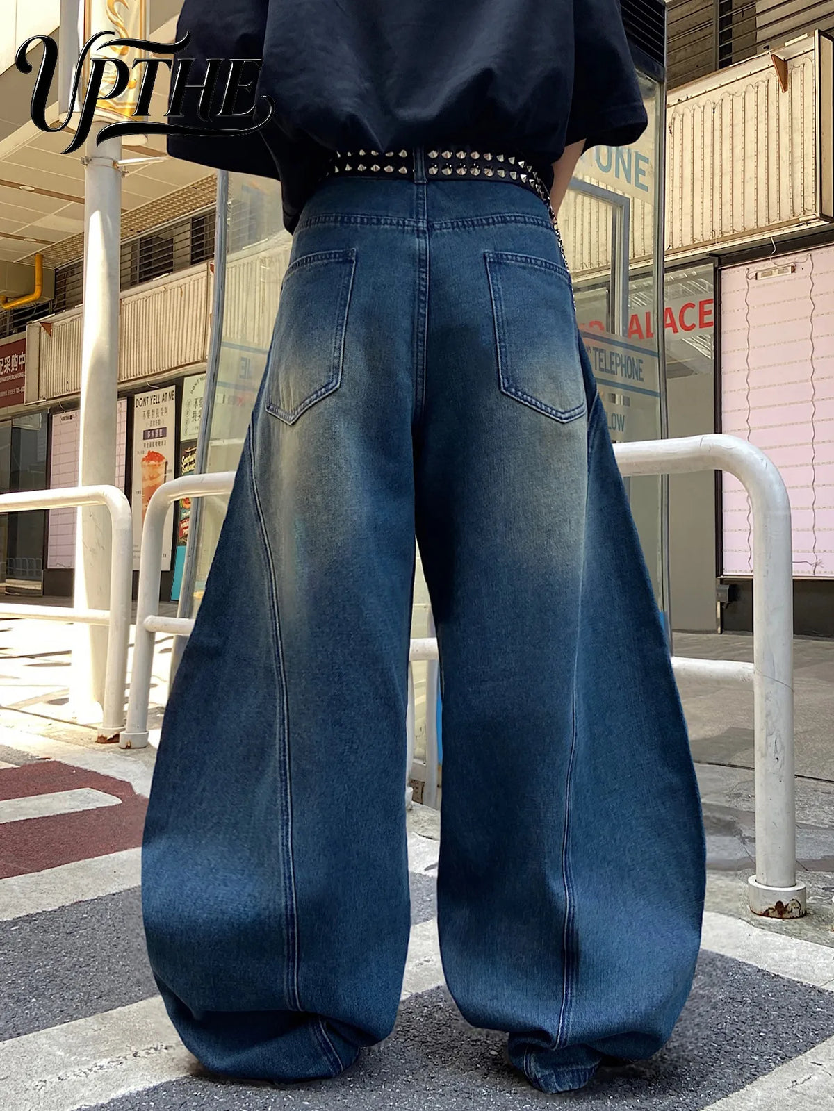 Back view of men's vintage blue baggy wide-leg jeans with spliced denim design