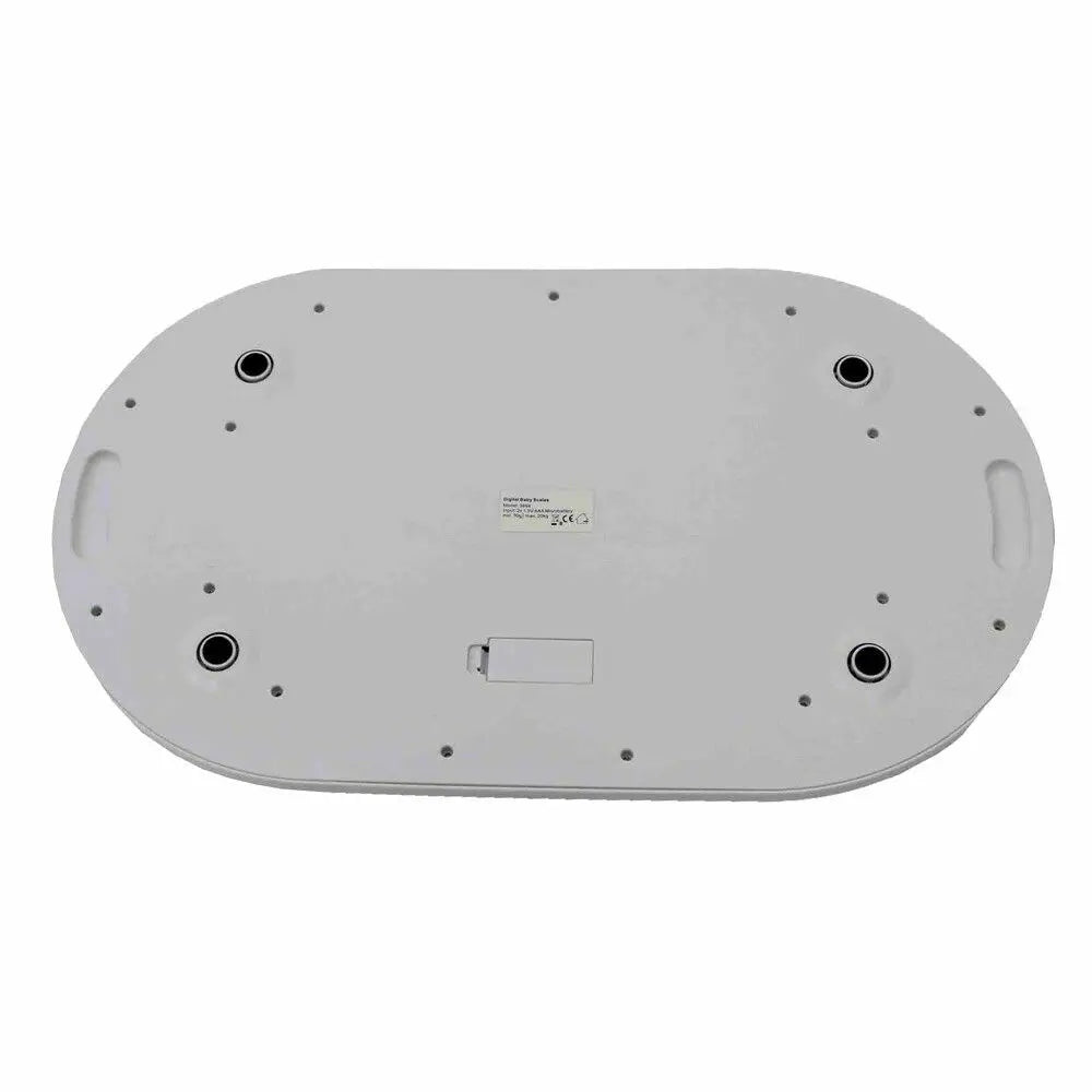 Bottom view of a white digital baby scale showing battery compartment and rubber feet