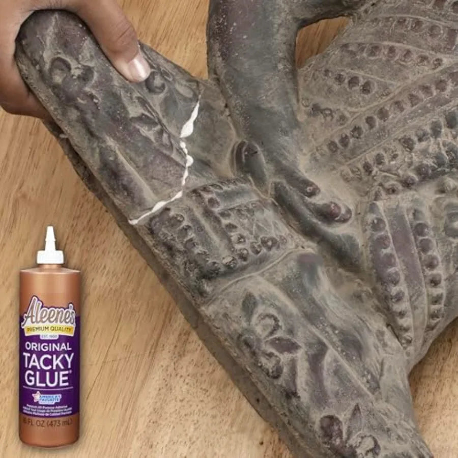 Hand using craft adhesive to repair a broken ceramic statue